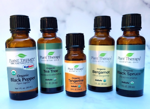 Bottles of Black Pepper, Tea Tree, Tangerine, Bergamot, and Black Spruce essential oils from Plant Therapy.