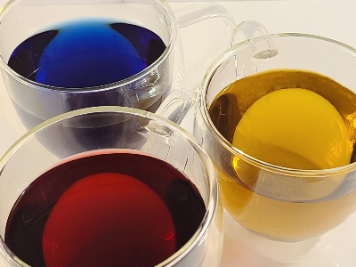 Green, yellow, and red herbal teas in glass tea cups 